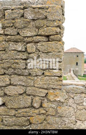 Die Festungsmauer besteht aus Naturstein. Uralter Kalkstein. Kreativer Vintage-Hintergrund. Ukraine. Belgorod - Dnestrovsky. Stockfoto