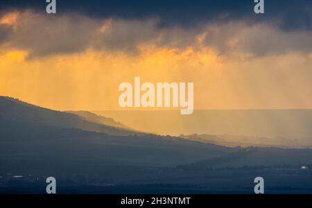 Morgendämmerung in den Bergen der Krim. Licht Dunst über den Bergen und Strahlen der Sonne durch die Wolken. Stockfoto