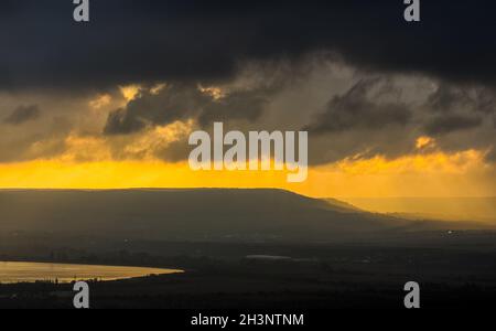 Morgendämmerung in den Bergen der Krim. Licht Dunst über den Bergen und Strahlen der Sonne durch die Wolken. Stockfoto