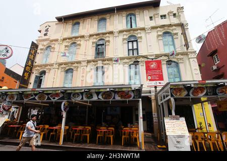 Eine Person, die an einem Restaurant in einem alten Geschäftshaus in der Pagoda Street in Singapurs Chinatown vorbeigeht. Stockfoto