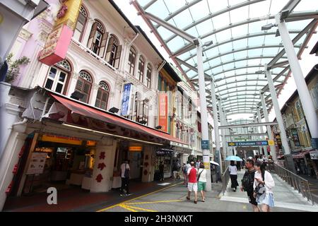 Die North Bridge Road, Ende der Pagoda Street mit überdachtem Gehweg, Geschäften und Restaurants und mit mehreren Leuten, die in Singapurs Chinatown spazieren. Stockfoto