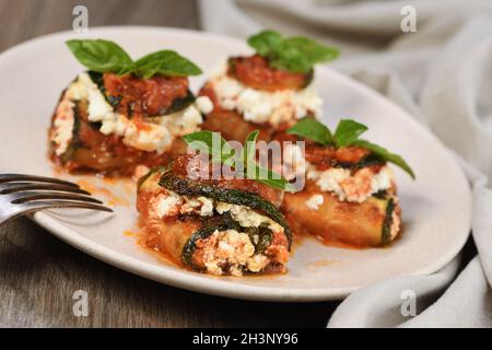 Gebackene Zucchini Brötchen gefüllt mit Ricotta und Basilikum unter Tomaten - Zwiebel - Sauce Stockfoto