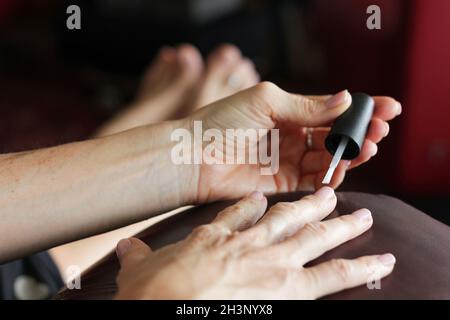 Frau, die Nagellack anwendet. Selbstmaniküre-Konzept Stockfoto