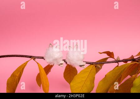 Zwei Haarnadeln in der Liebe auf einem Ast. Minimales kreatives Konzept mit Herbstelementen. Stockfoto