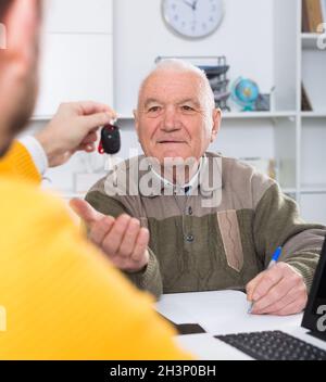 Mann, der im Büro ein Auto kauft Stockfoto