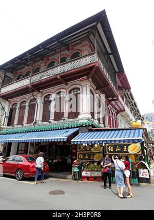 Kreuzungspunkt zwischen Temple Street und Trengganu Street mit alten Ladenhäusern, Geschäften und Ständen und Menschen, die in Singapurs Chinatown spazieren. Stockfoto