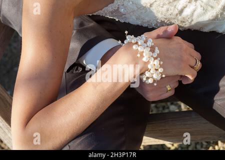 Gerade verheiratete Paar Hände, Braut und Bräutigam Hände mit schwarz-weiß Gold Diamant Eheringe halten zusammen, weiß vermählt Stockfoto