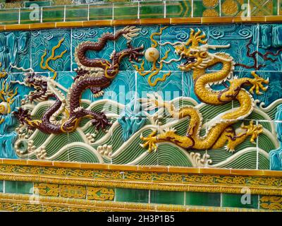 Mosaik von Drachen auf chinesischem Sarkophag. Dekorationen aus Fliesen. Stockfoto