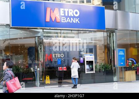 Eine Kundin wartet am Vordereingang der METRO Bank-Niederlassung in der City of London, England Stockfoto