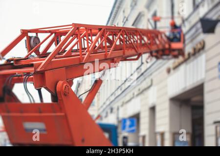 Luftarbeitsbühne Fahrzeug während der Fassade Dekoration, orange Teleskopaufzug auf der Baustelle, Vermietung AWP arbeiten in den Straßen der Stadt, Motor Stockfoto