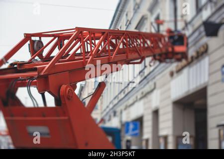 Luftarbeitsbühne Fahrzeug während der Fassade Dekoration, orange Teleskopaufzug auf der Baustelle, Vermietung AWP arbeiten in den Straßen der Stadt, Motor Stockfoto