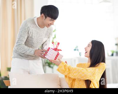 Der Mann schenkt der Frau ein Geschenk, um ihren Urlaub zu feiern Stockfoto