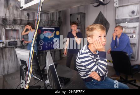 Nachdenklicher Teenager Junge, der Rätsel im Fluchtzimmer löst Stockfoto