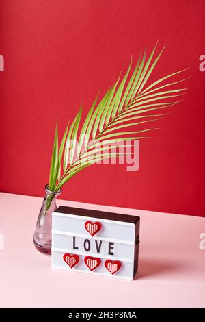 Liebe Leuchtkasten Nachricht mit roten Herzen auf rosa und rotem Hintergrund Stockfoto