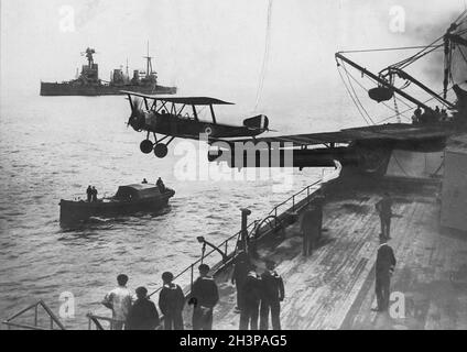 Ein Doppeldecker von Sopwith Strutter hebt 1918 von einer Plattform auf dem HMAS Australiens Mittelschiff-Turm „Q“ ab. Stockfoto