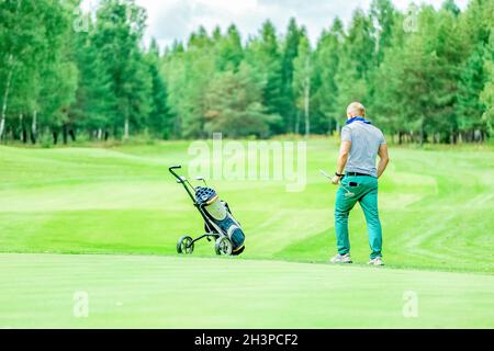 Blick von hinten, ein Mann spielt Golf auf einem Waldgrund. Hochwertige Fotos Stockfoto