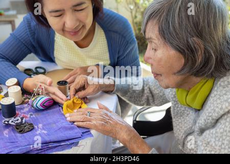 Ältere Frauen und Töchter in der Nadel basteln Ergotherapie für Alzheimer oder Demenz Stockfoto