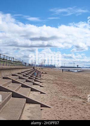 Menschen am Strand von blundell Sands in crosby in der Nähe von southport merseyside mit Geländern am Meer und Liverpools Docks Stockfoto