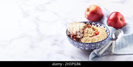 Haferflocken mit karamellisierten Äpfeln mit Zimt, Banane und geriebenen Erdbeeren Stockfoto