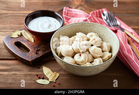 Knödel mit Fleisch und Sauerrahm, Pelmeni russisches Nationalgericht Stockfoto