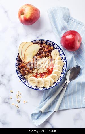 Haferflocken mit karamellisierten Äpfeln mit Zimt, Banane und geriebenen Erdbeeren Stockfoto