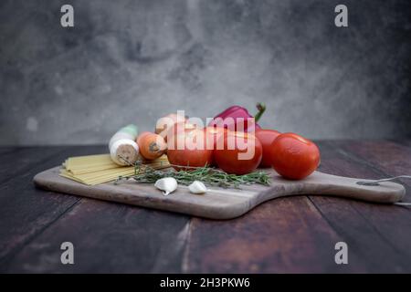 Verschiedene Zutaten zum Kochen italienischer Lasagne auf Holzboden. Stockfoto