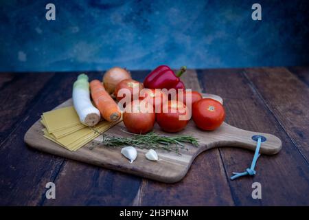 Verschiedene Zutaten zum Kochen italienischer Lasagne auf Holzboden. Stockfoto