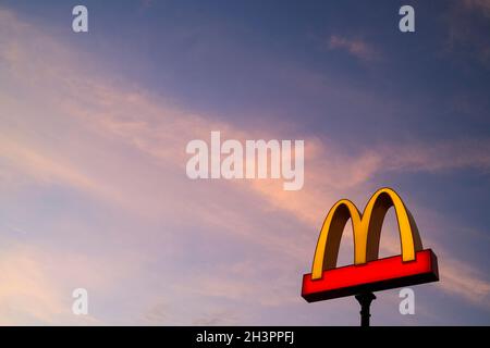 Das goldene MacDonald-Logo bei Sonnenuntergang Stockfoto
