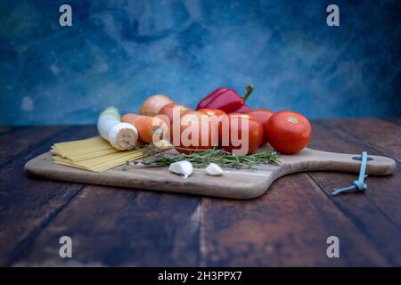 Verschiedene Zutaten zum Kochen italienischer Lasagne auf Holzboden. Stockfoto