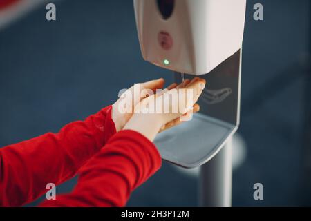 Kind Junge Kind mit automatischen Alkohol-Gel-Spender Sprühen auf Hände Desinfektionsmaschine antiseptische Desinfektionsmittel, neues normales Leben Stockfoto