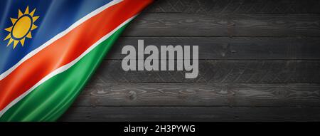 Namibische Flagge auf schwarzem Holz-Wandbanner Stockfoto
