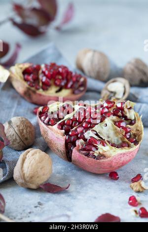 Mehrere reife Granatapfelfrüchte und Walnuss. Granatapfel sind reich an Kalium, Magnesium, Kalzium, Eisen und Mangan. Stockfoto