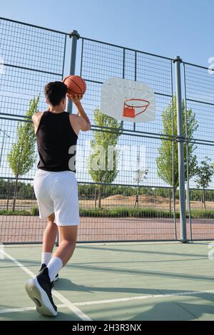 Basketballspieler, der den Ball in den Korb wirft. Stockfoto