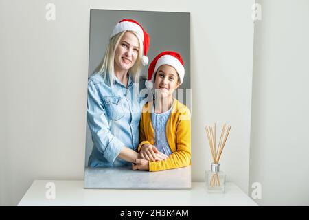 Foto auf Leinwand gedruckt, weißer Hintergrund. Glückliche junge Familie in Santa Hüte Weihnachten zu Hause feiern Stockfoto