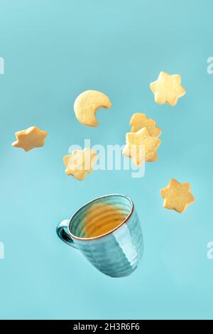 Dänische Butterkeks und eine Tasse Tee auf blauem Hintergrund Stockfoto