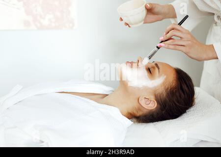 Crop-Kosmetologe Anwendung Gesichtsmaske auf Client Stockfoto