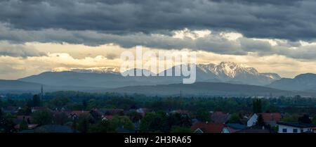 Berge Rax und Schneeberg in Niederösterreich bedeckt mit Schnee und dunklen Wolken am Morgen Stockfoto