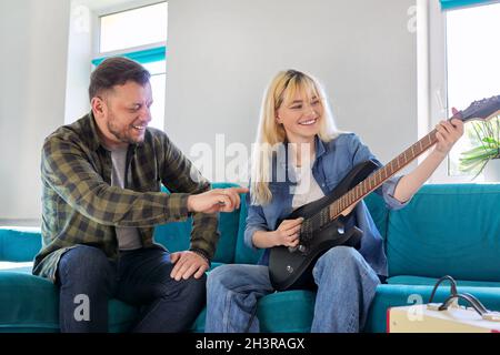 Vater lehrt Teenager-Tochter, die E-Gitarre zu spielen. Stockfoto