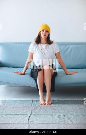 Stilvolle Frau sitzend auf sofa Stockfoto