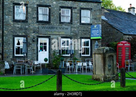 Alte malerische attraktive Teestuben außen, in malerischen ländlichen Dorf (Sitzgelegenheiten, geschlossen, zum Verkauf Schild an der Wand) - Burnsall, Yorkshire Dales, England, Großbritannien. Stockfoto