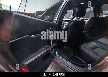 Modernes Luxusauto im Inneren. Bequeme schwarze Ledersitze - Rücksitz für die Passagiere Stockfoto