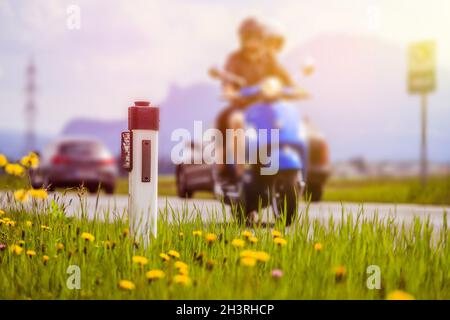 Straße im Sommer: Paar auf dem Motorrad, Blumen und grünes Gras Stockfoto