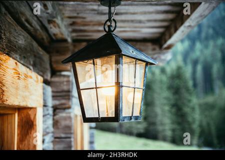 Laterne hängt auf der Veranda einer alten Holzhütte Stockfoto
