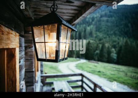 Laterne hängt auf der Veranda einer alten Holzhütte Stockfoto