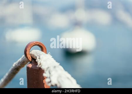 Segeln: Segelseil auf hölzernen Dock Pier. Segelboote im Hintergrund. Stockfoto