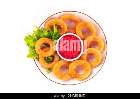 Calamari-Ringe, isoliert. Ein Teller mit frittierten Tintenfisch-Ringen mit grünem Salat Stockfoto