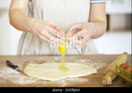 Crop Frau bereitet Teig am Tisch zu Hause Stockfoto