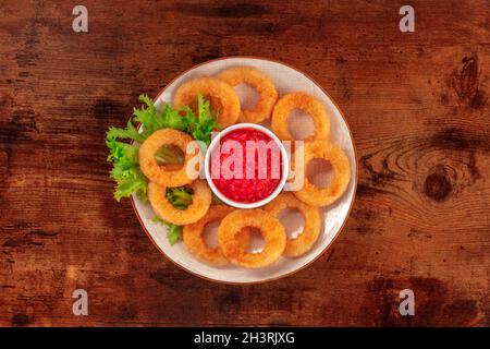 Tintenfischringe. Frittierte Calamari-Ringe mit Salat und Ketchup Stockfoto