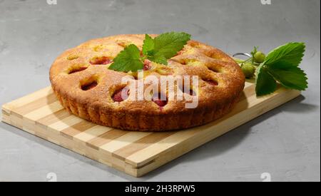 Runder Biskuitkuchen mit Erdbeeren auf Holzbrett Stockfoto