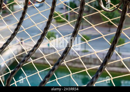 Nahaufnahme von Eisengeländern und starken Netznetzen, die Kinder und Haustiere vor dem Sturz vom Balkon schützen. Stockfoto